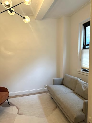 Living room area with couch and lamp in office setting